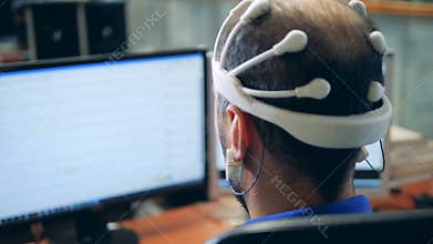 Monitor with information transmitted from an EEG headset put on a man