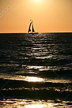 Sailboat on the horizon at sunset