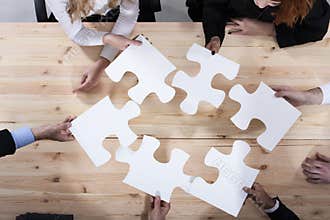Business people work together to build a puzzle. Concept of teamwork, partnership, integration and startup