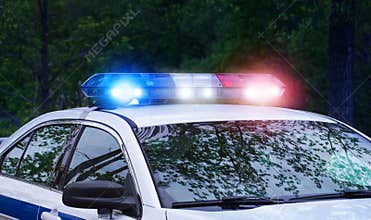 Real patrol police car with siren lights at night time. Beautiful siren lights activated in full mission activity. Policemen with