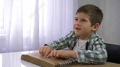 Blind child boy reading braille book with symbols font for Visually impaired sitting at table