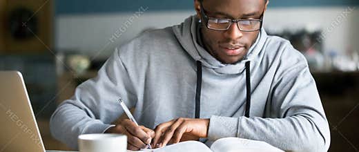 Horizontal photo african student study writing using book and computer