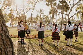 Irish Group of Bagpipe and Drummer Musicians Wearing Authentic European Kilts While Performing Traditional Celtic Music