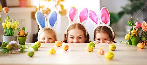 Happy easter! family mother and children with ears hare getting ready for holiday