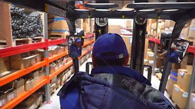 Forklift trucks move between large metal shelves at modern warehouse with pallets with cardboard boxes, Logistics