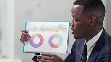 Portrait of afro american businessman rendering annual accounts