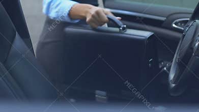 Lady boss getting out of automobile, taking bag and walking to business center