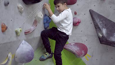 Boy climbing indoor rock wall