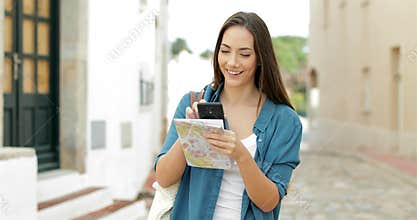 Happy tourist checking location walking in the street