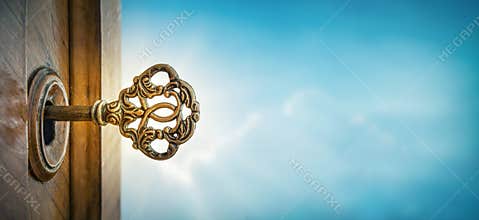 Old key in keyhole on sky background with sun ray . Concept, symbol and Idea for History, business, security background