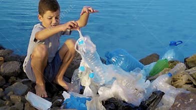 Litle child volunteer cleaning up the beach at the ocean. Safe ecology concept.