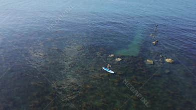 Aerial View of Clear Blue Seascape with Person Riding Stand Up Paddle Board SUP