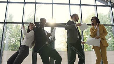 Diverse group female and male business team are celebrating success of company and throwing papers documents, Happy