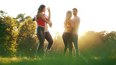 Women and men having fun dancing in the park