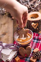 Gingerbread cookie in the female hand and aromatic fresh coffee. Holiday atmosphere and Christmas. Free space for text