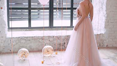 Light bright balloons lie and roll on floor, filled with golden serpentine, glitter in the light of the sun, cute lovely