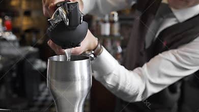 Bartender squeezes juice to the cocktail shaker, making of the cocktails, barman at work, at the bar counter