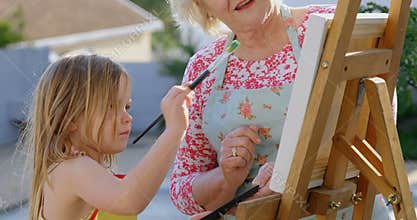 Granddaughter and grandmother painting on canvas 4k