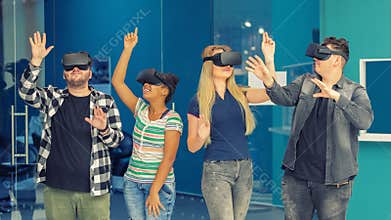Multiracial friends group playing on vr glasses indoors. Virtual reality concept with young people having fun together.