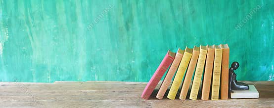 Row of multicolored hardback books and an old bookstand, reading education, literature