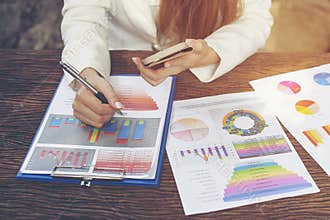 Business report, mobile phone and business summary laid on desk. Online and internet for connectivity. Business work at home