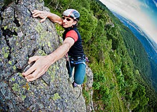 Young white man climbing a steep wall