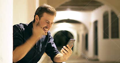 Excited man finding online phone content in the night
