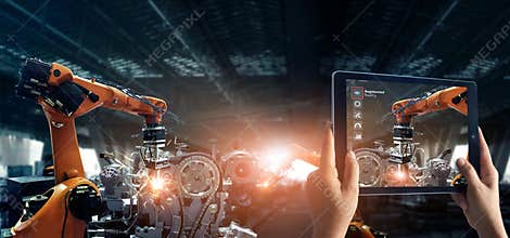 Augmented reality industry concept. Hand holding digital tablet use AR application to check and control welding robotics automatic