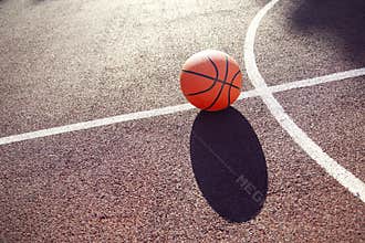 Basketball court with ball in sun light