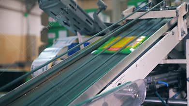Plastic packaging moving up on automated conveyor at a factory.