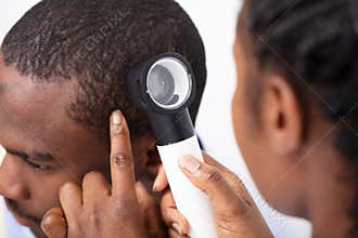 Doctor Examining Man`s Hair With Dermatoscope