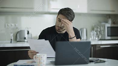 Thoughtful man working with documents at home. Business man doing paperwork