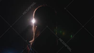 Close-up of the face of the singer with microphone on a black smoky background. The singer sings a song on stage in the