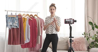 Teenage fashion vlogger presenting new outfit in front of mobile camera