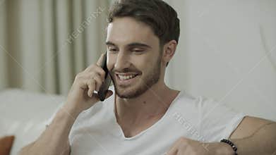 Happy man talking mobile phone. Portrait of smiling man call cell phone at home