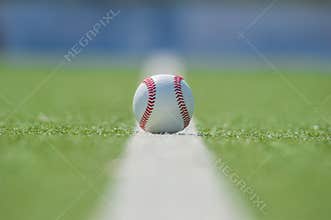 White ball for playing baseball on the grass background