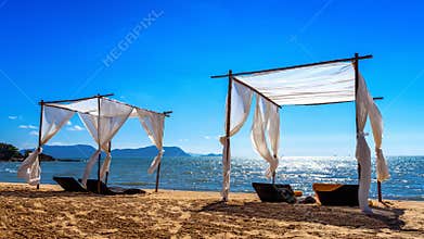 Beach canopies with sun loungers on beach