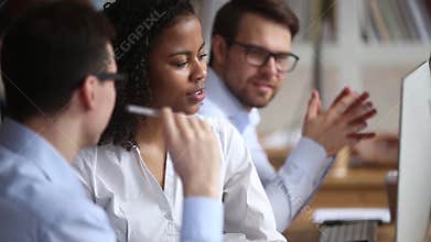 Diverse colleagues working together discussing online computer project at workplace