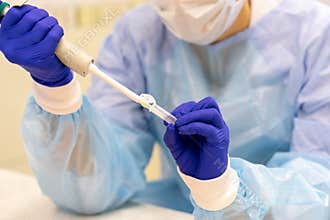 Laboratory assistant with a pipette in his hands for blood testing