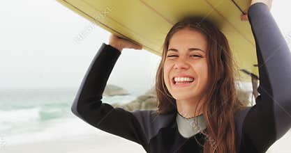 Front view of Caucasian female surfer carrying surfboard on her head at beach 4k