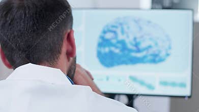 Over the shoulder shot of doctor head looking at 3D brain simulation