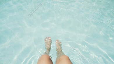 Female elegant legs in the pool. View from above. Azure water. 4K