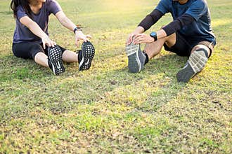 Early morning workout, Fitness couple stretching outdoors in park. Young man and woman exercising together in morning, Living