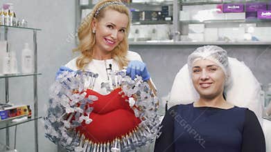 Doctor holds symbol of clinic - toy big lips with syringes