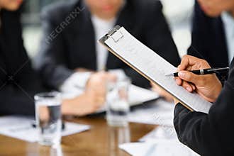 Hand writing with other business people