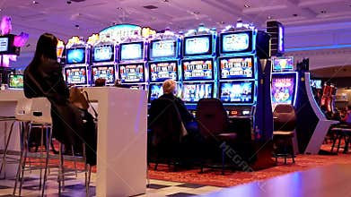 Motion of people playing slot machine and having fun inside Casino