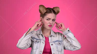 Girl screams, she does not want to hear anything. Pink background. Slow motion