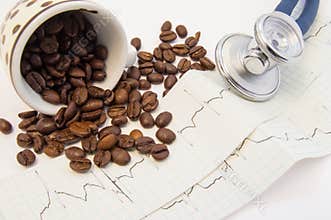Coffee beans spilled from c and scattered on paper ECG near medical stethoscope. Effect of coffee and caffeine on cardiovascular s