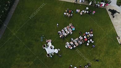 Wedding ceremony location with bride and groom, path between guests white chairs