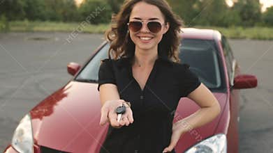 Happy girl with key in hand from new car